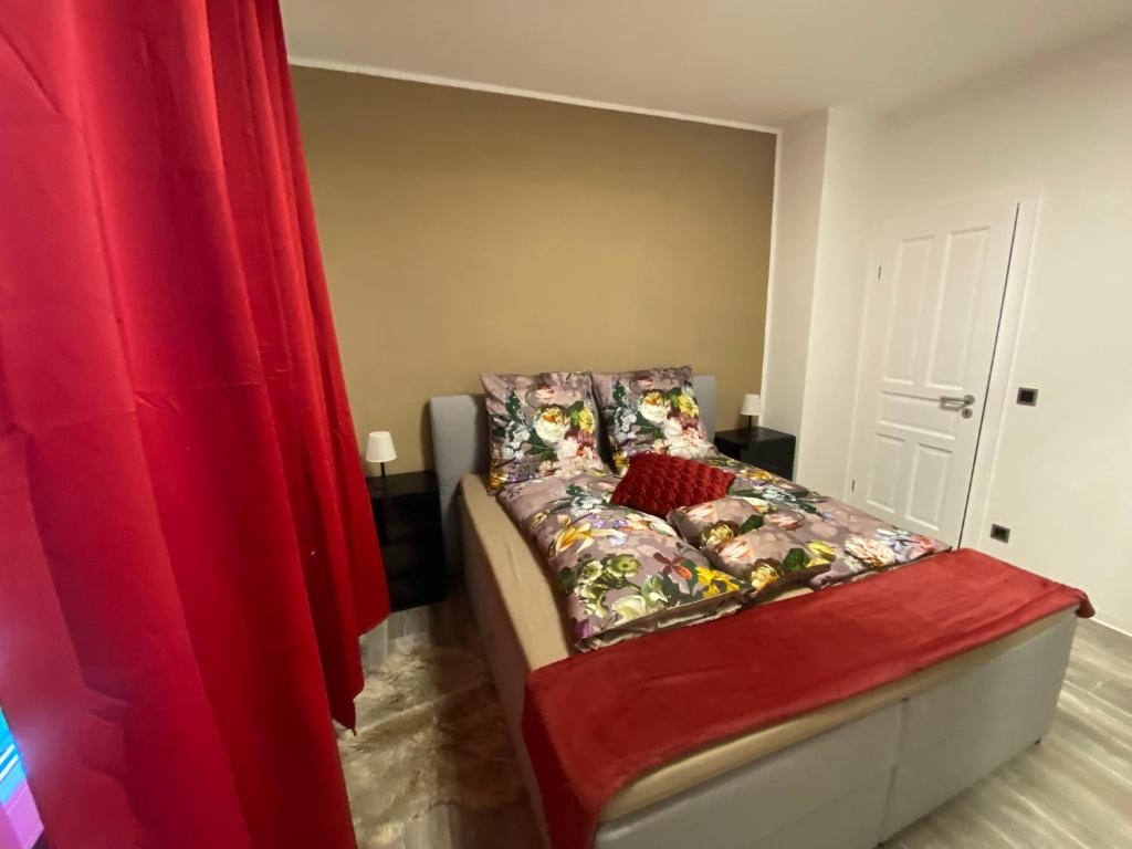 een slaapkamer met een bed met een rood gordijn bij Ferienwohnung Michelangelo Stadtmitte "Netflix" in Eisenach