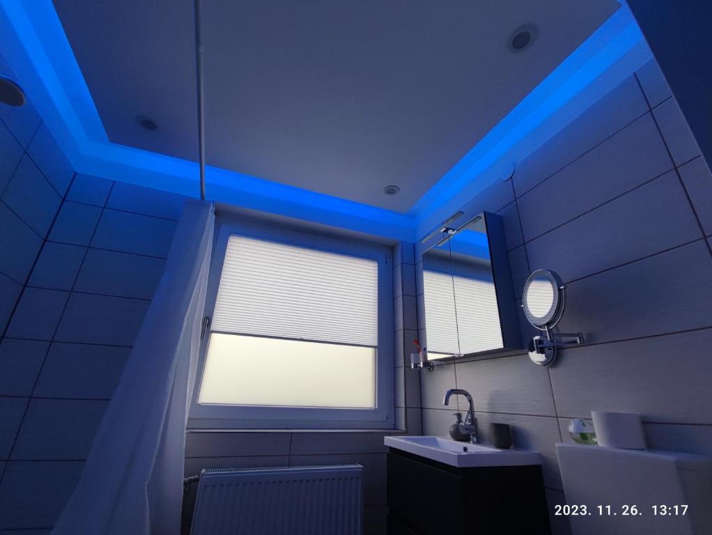 a bathroom with a blue ceiling with a window and a sink at Apartment Feldkirch in Feldkirch