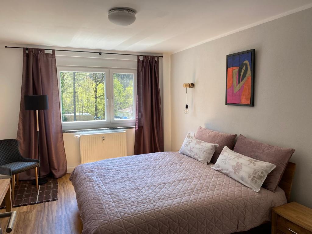 1 dormitorio con cama y ventana en Ferienwohnungen an der Schlösselmühle, en Amtsberg