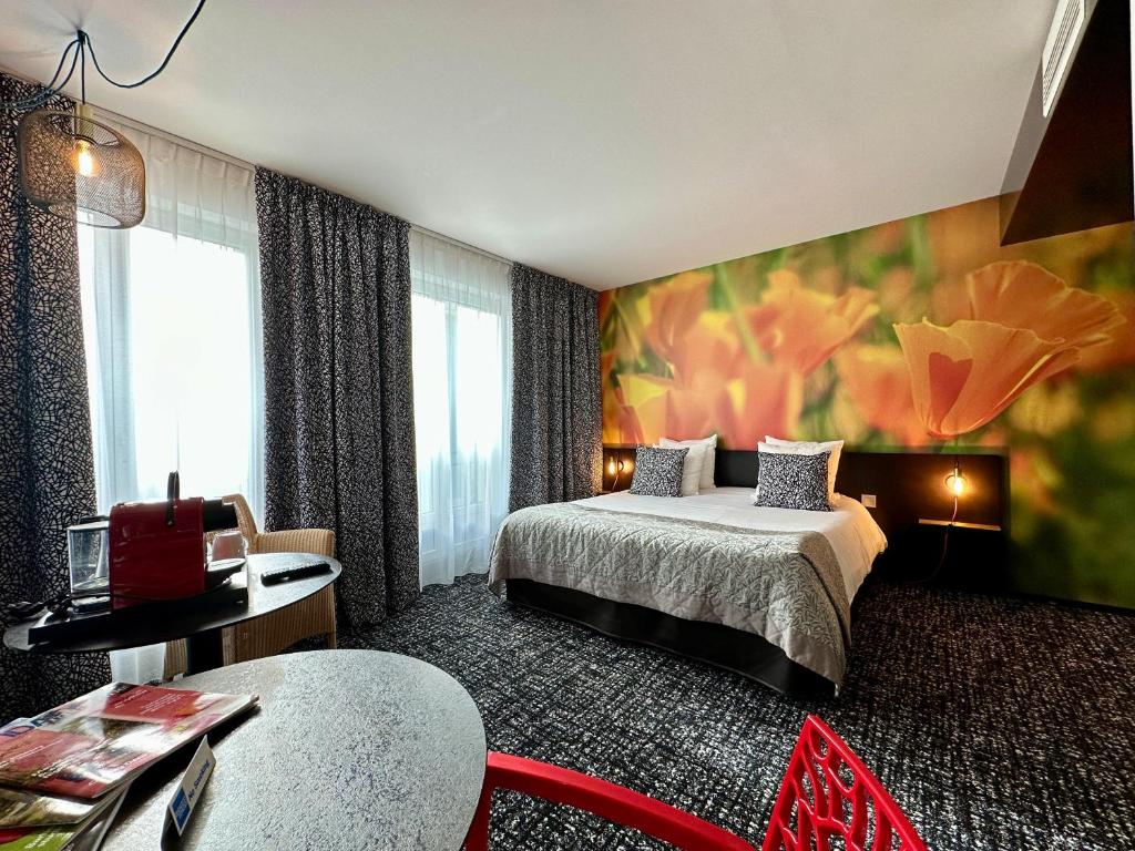 una camera d'albergo con due letti e un tavolo di La Paix Hôtel Contemporain Brest centre ville a Brest