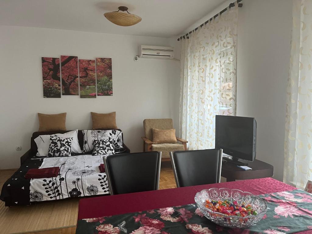 een slaapkamer met een bed en een tafel met stoelen bij Margita Apartment in Belgrado