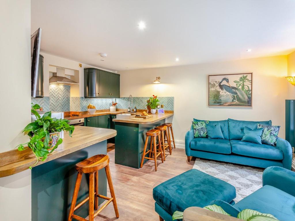 eine Küche und ein Wohnzimmer mit einem blauen Sofa in der Unterkunft The Garden Flat in Bath