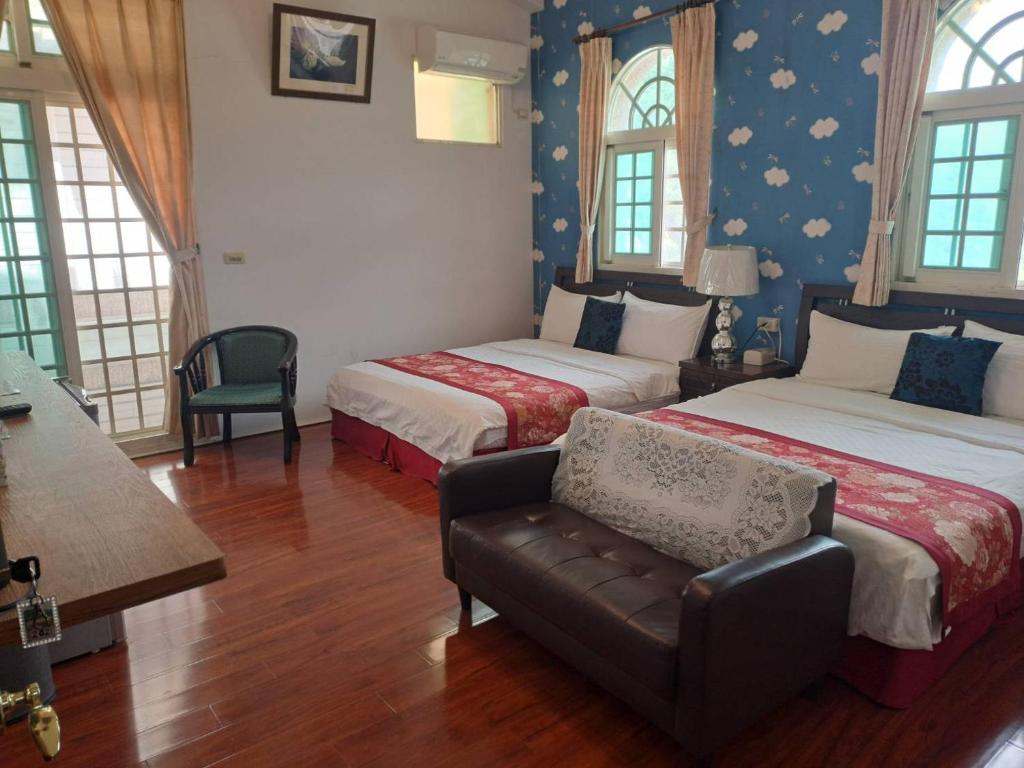 a hotel room with two beds and a chair at 太平山-部落山莊景觀民宿 in Datong
