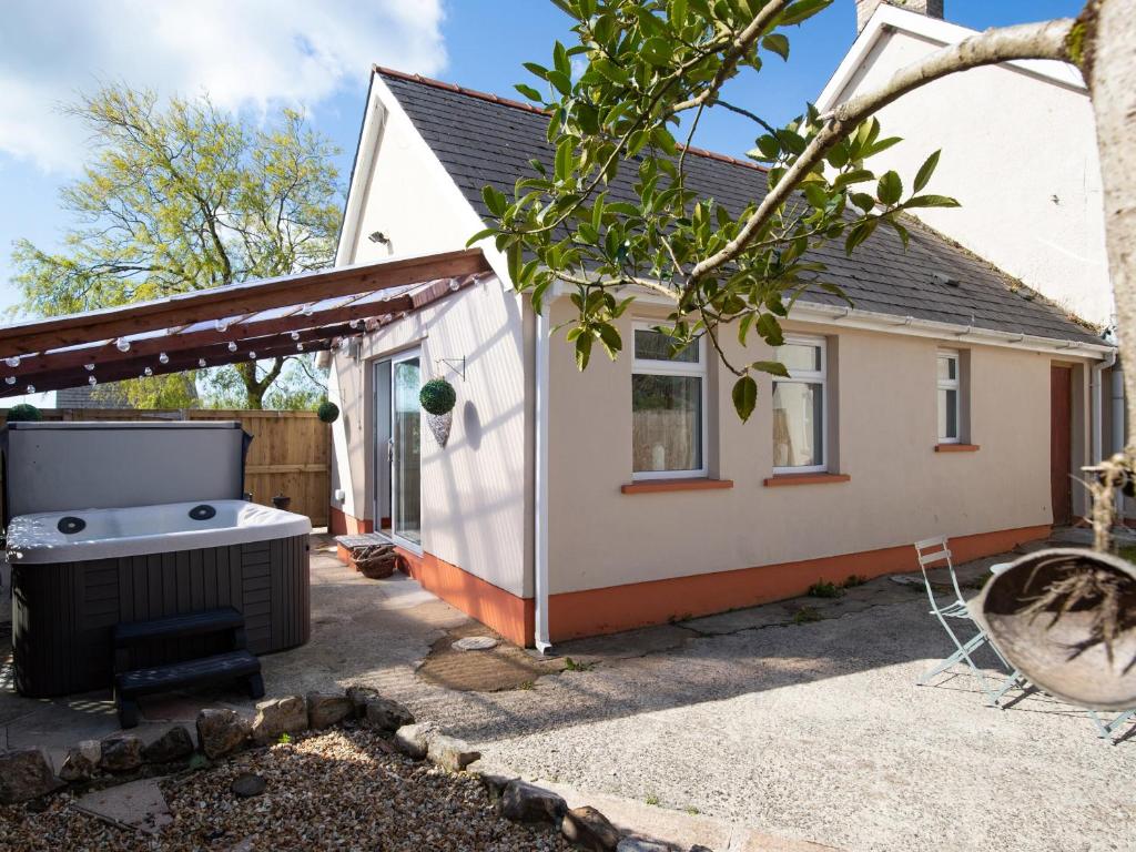 a backyard with a hot tub and a house at The Cwtch in Pembrokeshire