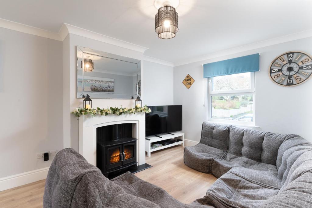 a living room with a couch and a fireplace at Large newly refurbished modern house, part sea views, south facing garden, parking in Penzance