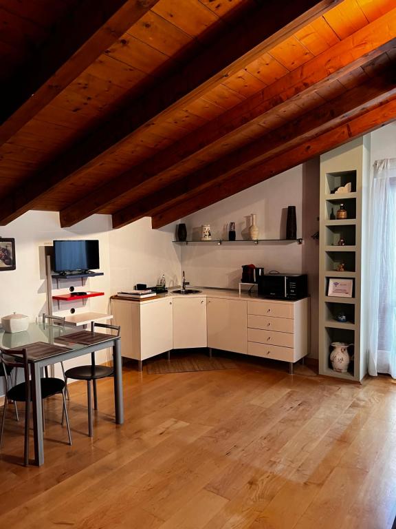 uma sala de estar com uma mesa e uma cozinha em La casetta di San siro em Milão