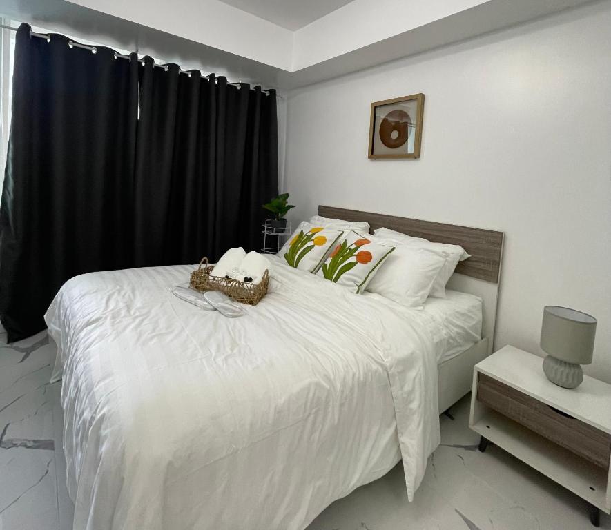 a bedroom with a white bed with a black window at Azure Urban Resort - CITY VIEW 1BR - PS4, Billiards, Netflix, Karaoke in Manila