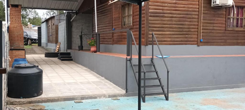 una scala appoggiata al muro accanto a un bidone della spazzatura di Cabañas niño9 a Villa Dolores