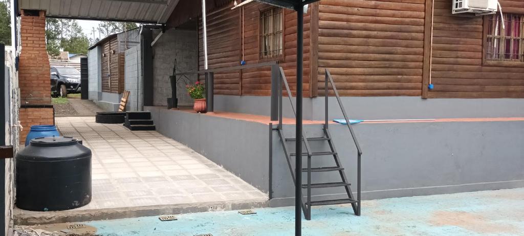 a ladder leaning against a wall next to a trash can at Cabañas niño9 in Villa Dolores