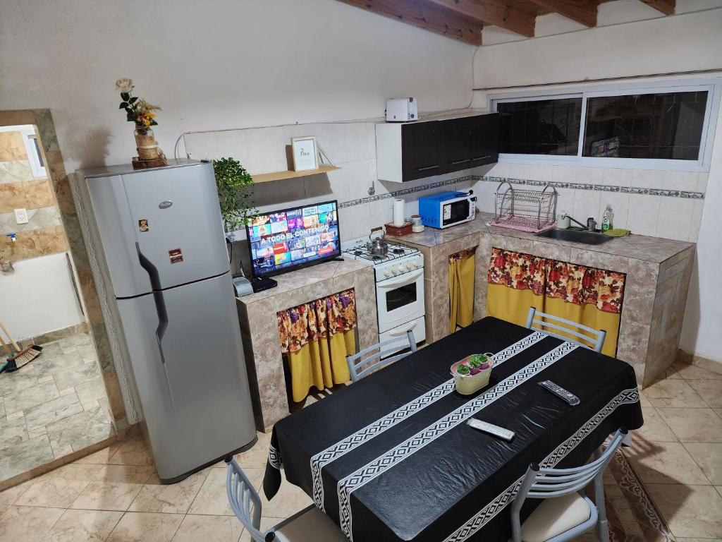 małą kuchnię ze stołem i lodówką w obiekcie Rincon house w mieście Rincon de los Sauces