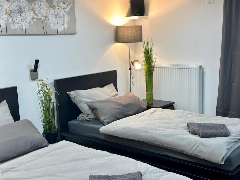 ein Schlafzimmer mit 2 Betten und einem Tisch mit einer Lampe in der Unterkunft Blauer Stein Apartments Doppelzimmer 1 in Pulheim