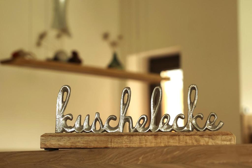 een metalen teken dat vriendelijkheid op een tafel zegt bij Ferienwohnung Kuschelecke in Michelstadt