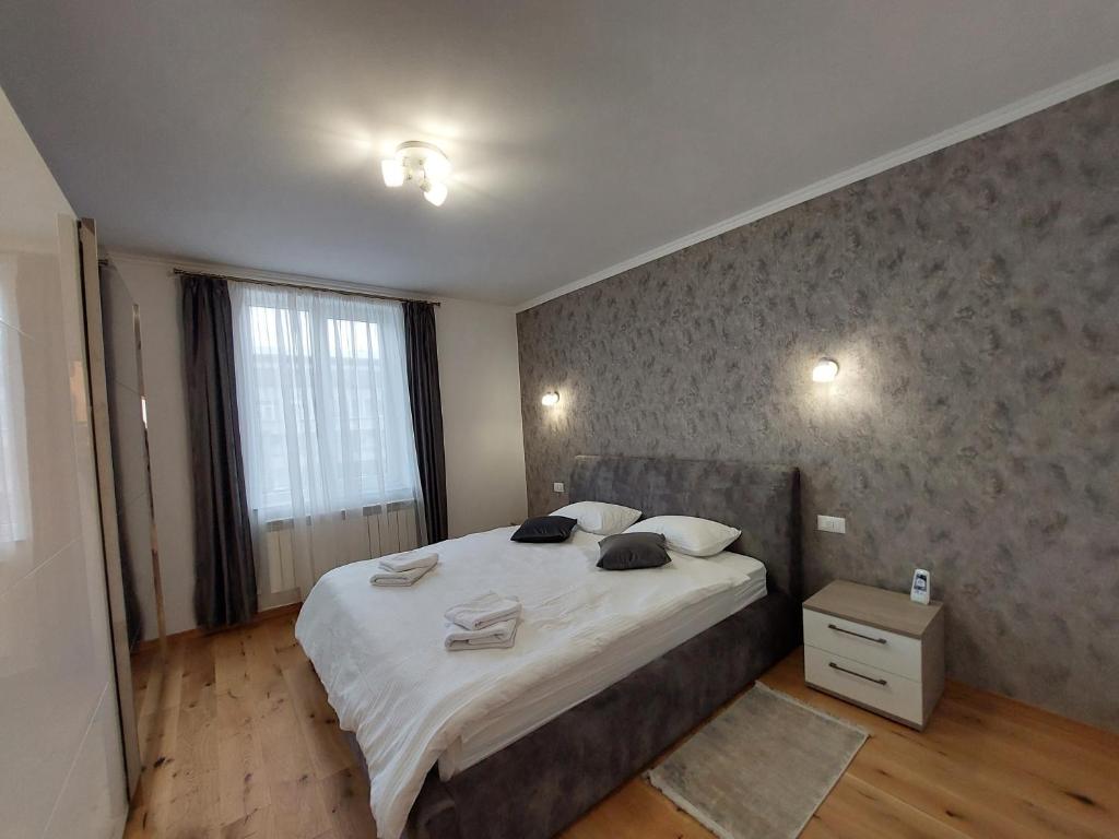 a bedroom with a large bed and a large window at Trandafirului Residence Central Suceava in Suceava