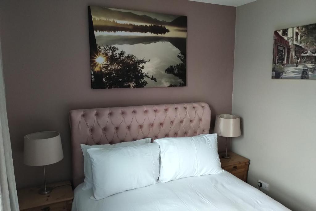 a bedroom with a white bed with two lamps at Oliver Wests Beautiful 2 Bedroom Sleeps 4 Apartment in Scarborough