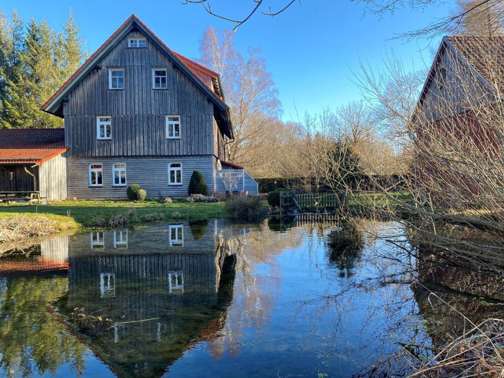 an old barn sitting next to a river at Altes Forsthaus im Harz in Elbingerode