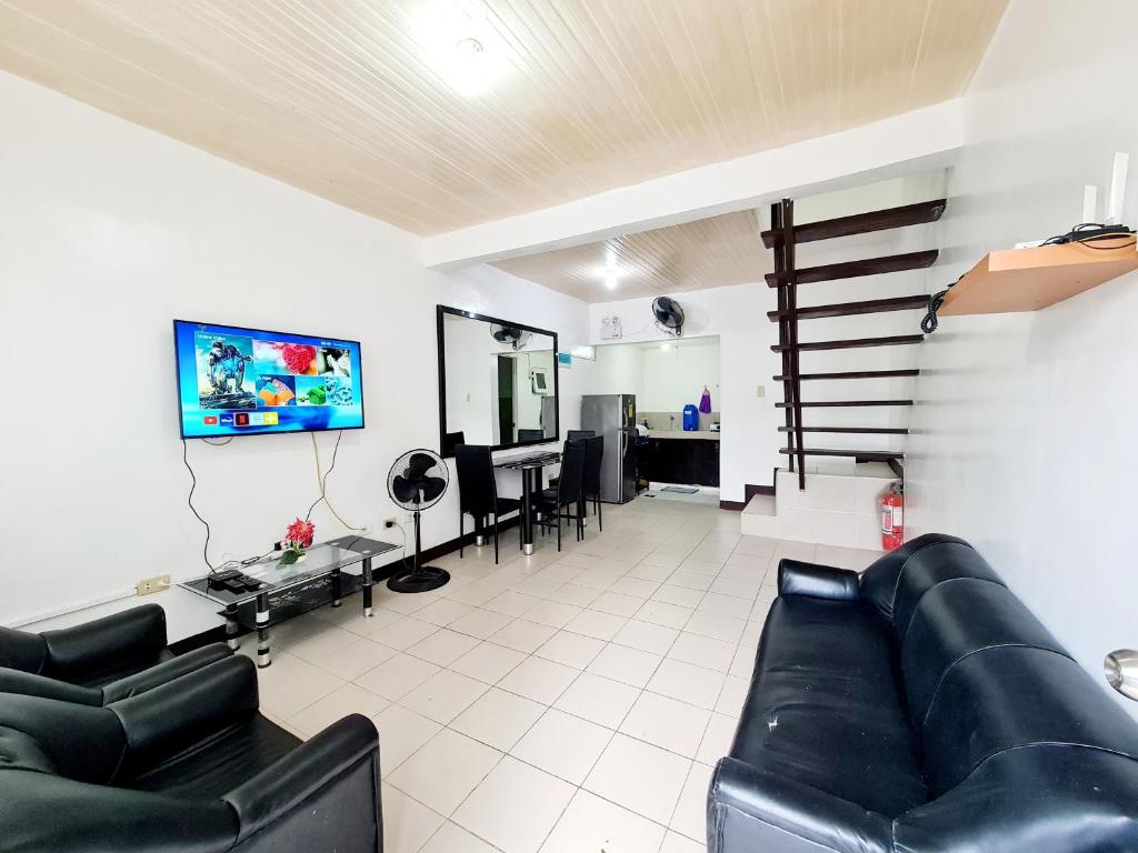 uma sala de estar com um sofá e uma televisão de ecrã plano em Calapan Transient Molave L48 em Calapan