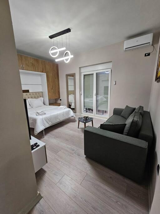 ein Wohnzimmer mit Sofa und Bett in der Unterkunft Studio near US Embassy with balcony in Tirana