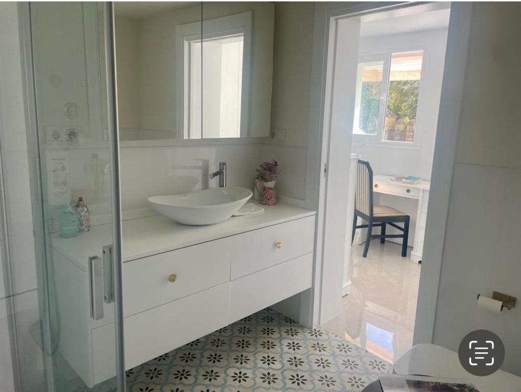 ein weißes Badezimmer mit einem Waschbecken und einem Spiegel in der Unterkunft Casa Muralla del Alcazar Viejo in Córdoba