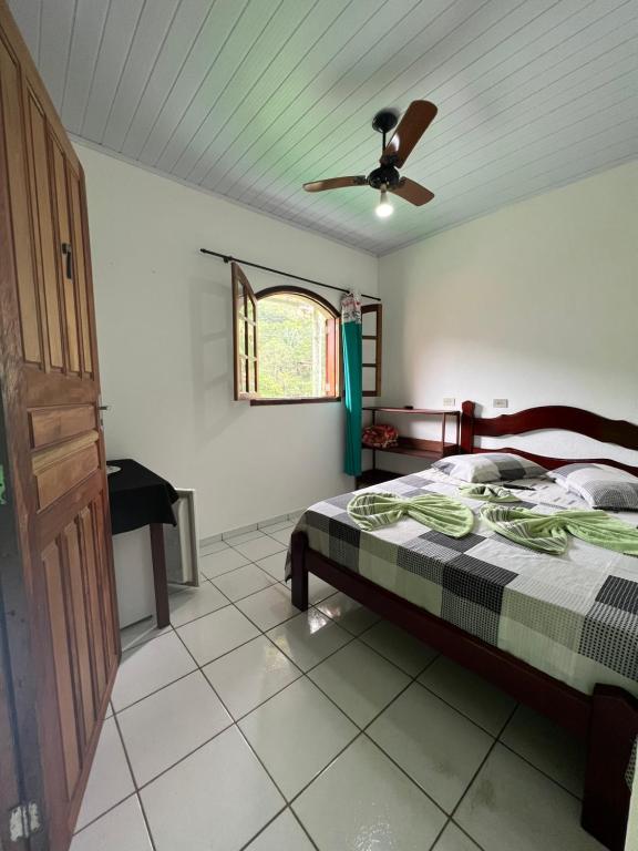 1 dormitorio con 1 cama y ventilador de techo en Pouso da Celeste - Trindade en Trindade