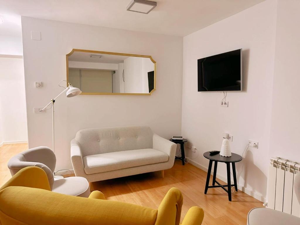 sala de estar con sofá, silla y espejo en Apartamento de Lucerito, en Jaca