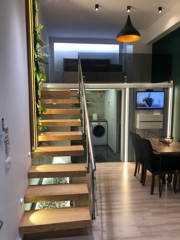uma escada numa casa com uma mesa e uma sala de jantar em Rent Room 2 Rolandi Apartments em Pogradec