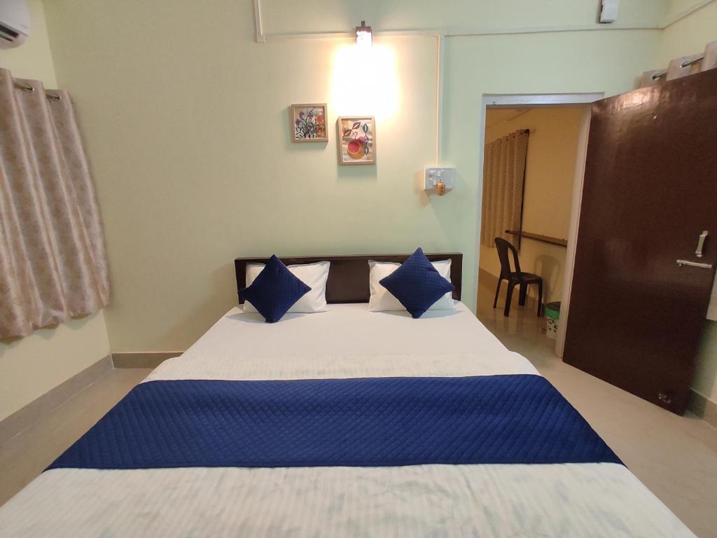 1 dormitorio con 1 cama grande con almohadas azules en THE STAY CORNER, en Guwahati