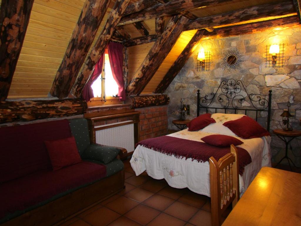 Casa Rural Fontamil في Gistaín: غرفة نوم بسرير واريكة في غرفة