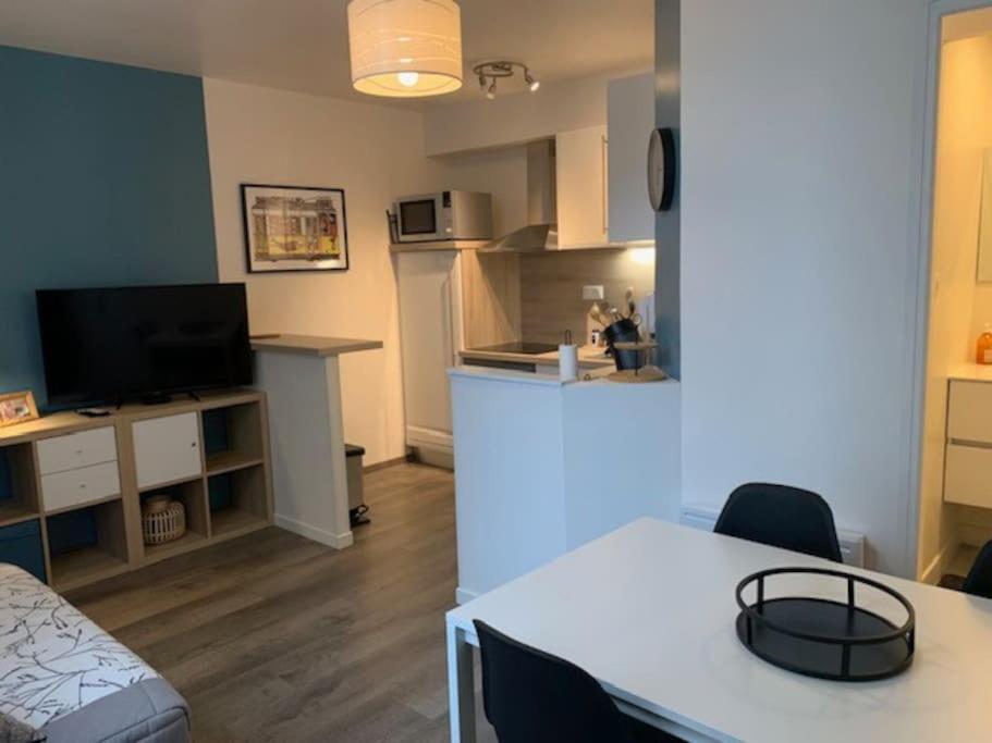 a room with a kitchen and a table with chairs at Etape saumuroise en centre-ville in Saumur