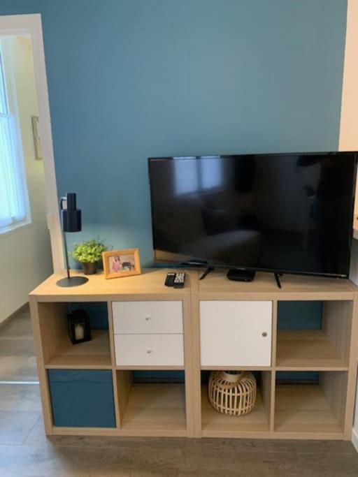 a wooden entertainment center with a flat screen tv at Etape saumuroise en centre-ville in Saumur