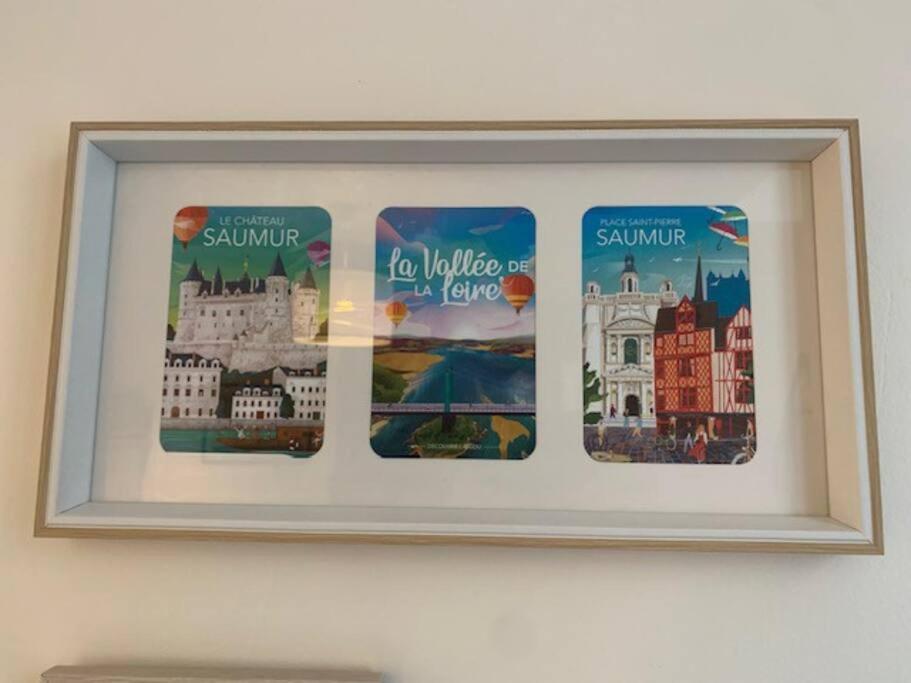 a picture of three cities in a frame on a wall at Etape saumuroise en centre-ville in Saumur