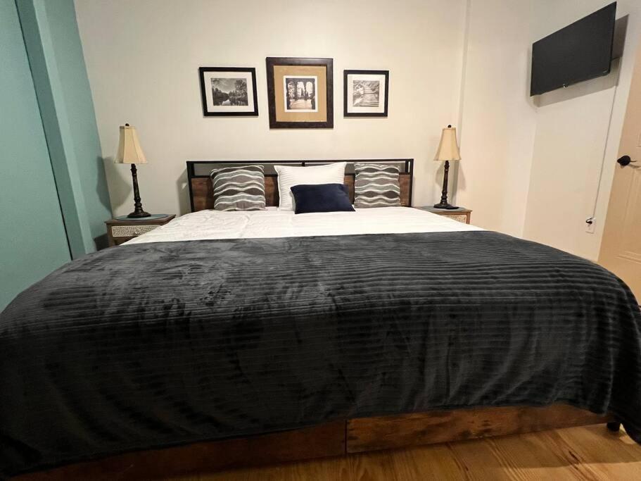 a bedroom with a large bed with a black blanket at Chic Two-Bedroom Apartment on Camp St, New Orleans in New Orleans