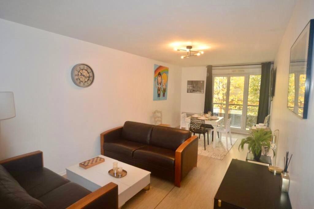 ein Wohnzimmer mit einem Sofa und einem Tisch in der Unterkunft Ideal family flat in st-ouen in Saint-Ouen