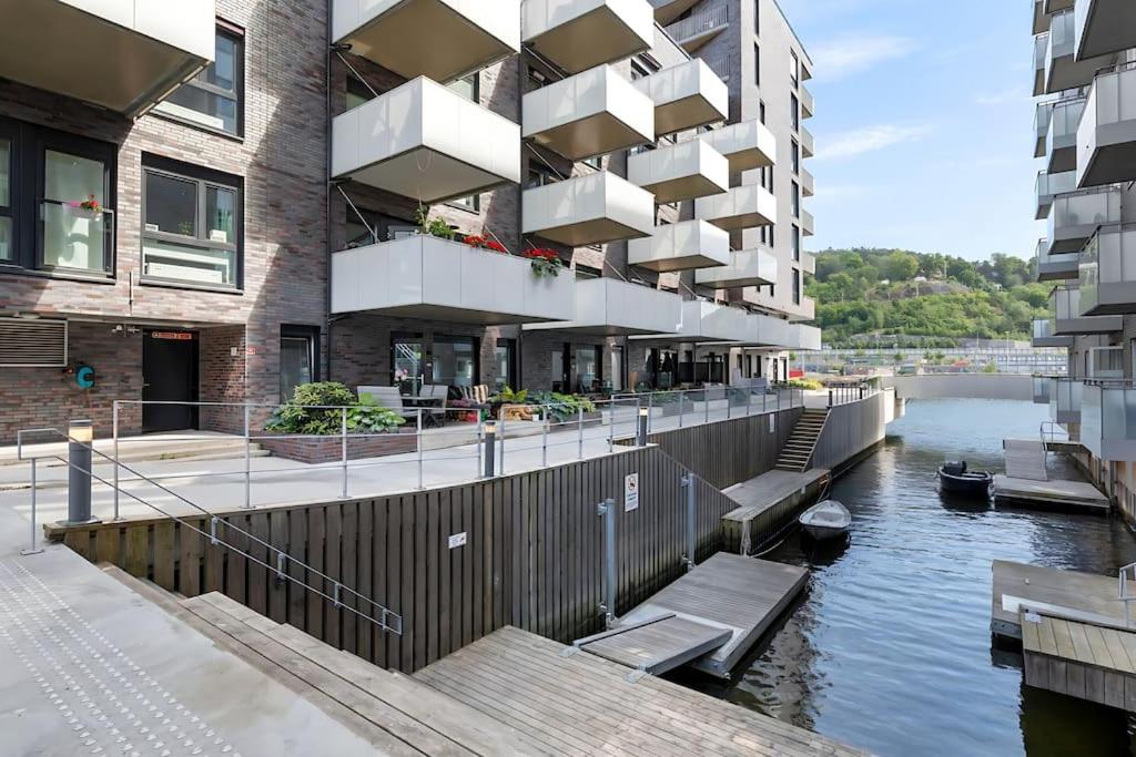 um edifício ao lado de um rio com um barco nele em Sørenga MUNCH ved kanalen - egen terrasse uteplass em Oslo