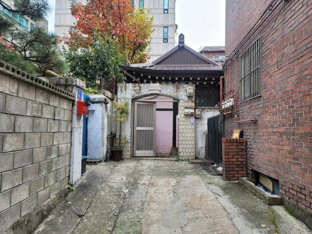 eine Gasse mit einer lila Tür und einem Gebäude in der Unterkunft BlueBird Guesthouse - Foreign Only in Seoul