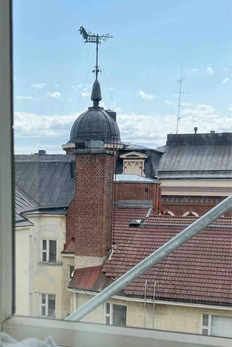 a view of a building with a tower and a roof at Kiinnostaako Helsingin historia? in Helsinki