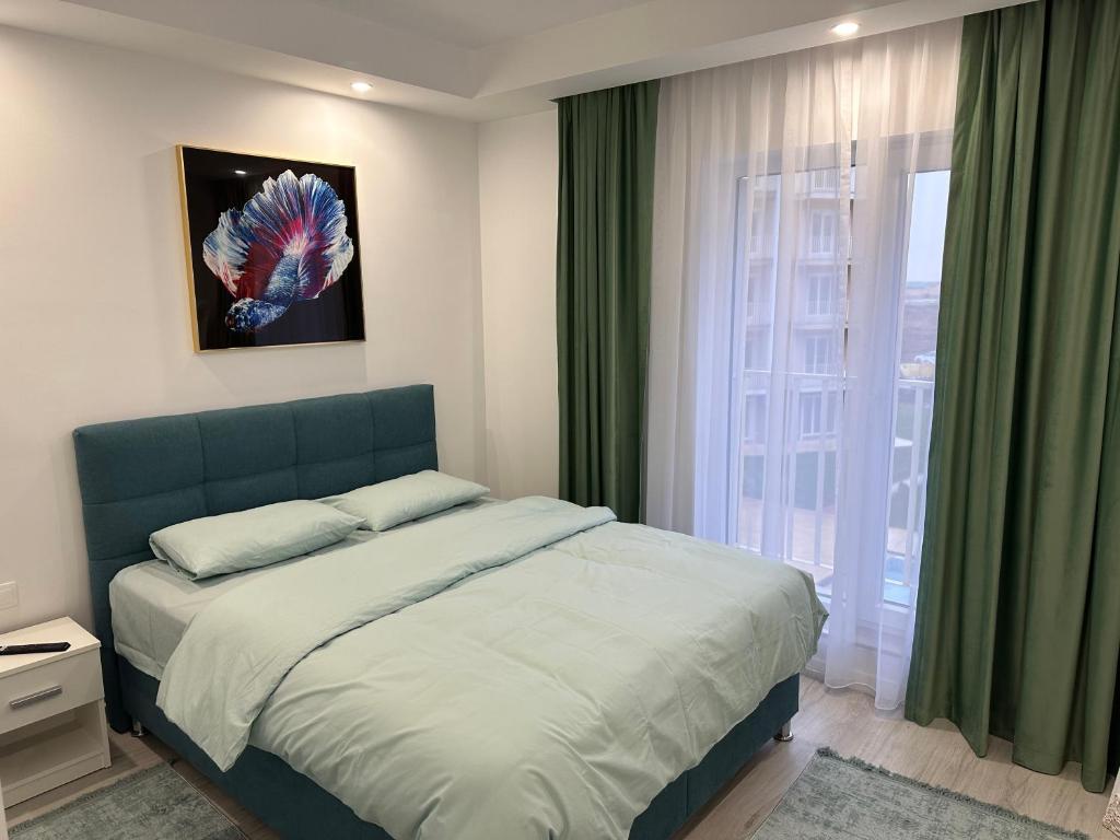 een slaapkamer met een bed en een groot raam bij Adagio apartment in Creţuleasca