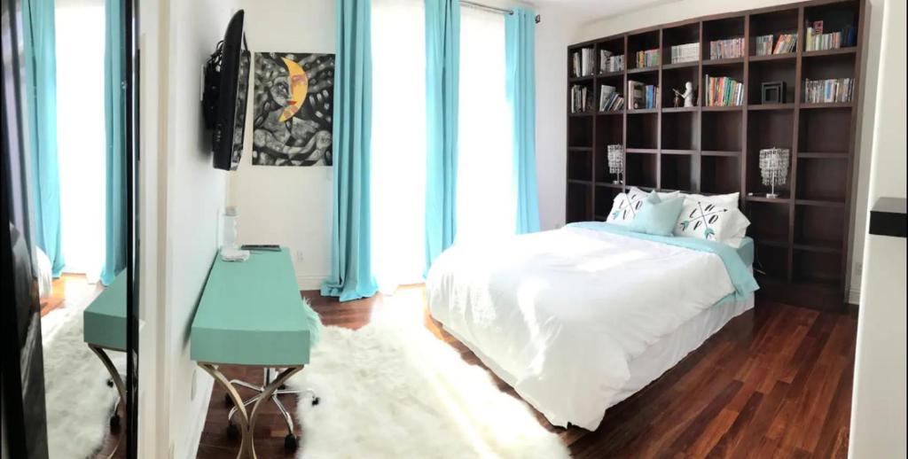 een slaapkamer met een bed en een boekenplank bij Hills of Studio City, your serene home away from Home in Studio City