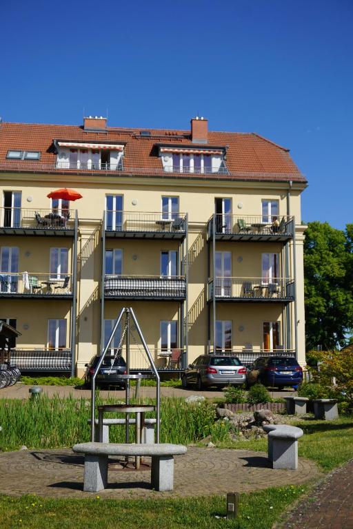 a playground in front of a large building at Apartmenthaus am Grienericksee in Rheinsberg