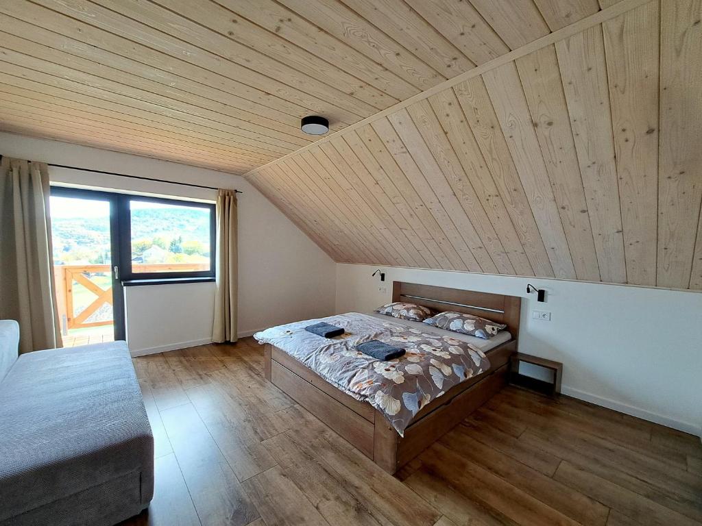 1 dormitorio con cama y techo de madera en U Hanky pod Hrbkom, en Repište
