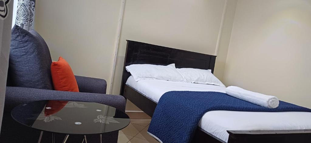 a room with two beds and a table and a chair at B&S Studio apartment, Voi Town in Voi