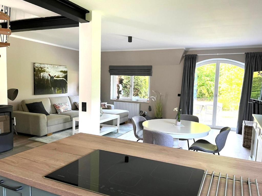 cocina y sala de estar con mesa y sillas en Reetdach-Landhaus Mini Haubarg en Tating