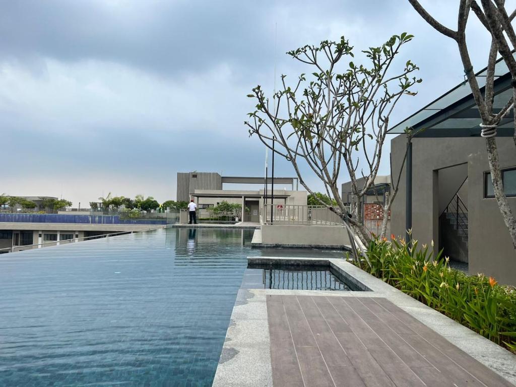 una piscina con agua frente a un edificio en Midnight Homestay Youth City en Nilai