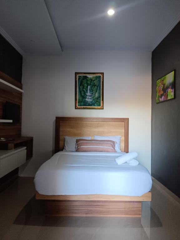 een slaapkamer met een groot wit bed in een kamer bij BALI MOUNT VIEW META PANDAWA in Jembrana