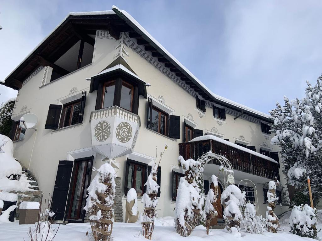 a large white house with snow on it at Chasa Tusa Scuol in Scuol