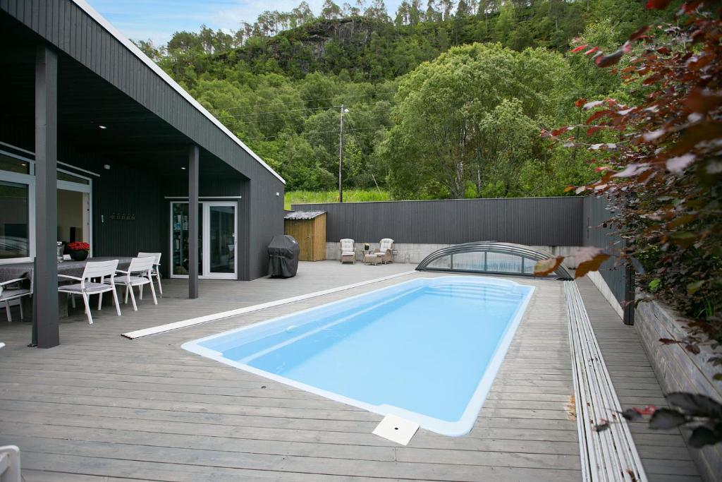 a swimming pool on a deck next to a house at Fantastisk sommerhus i Tennfjord, ved Ålesund. in Tennfjord