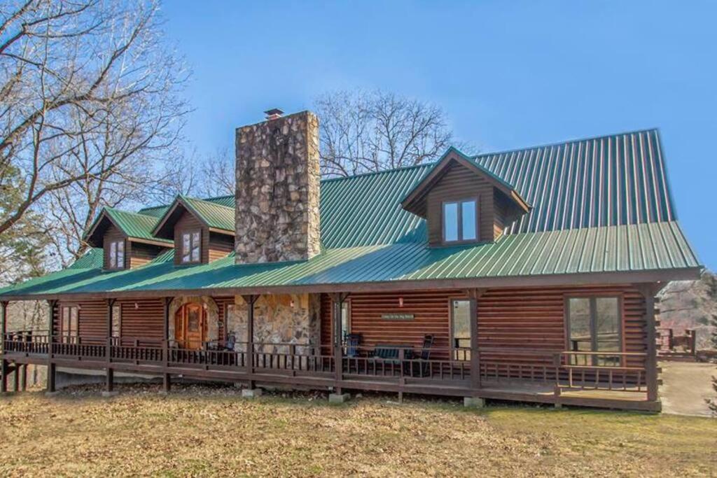 een groot houten huis met een groen dak bij Buffalo River Lodge St Joe AR in Maumee