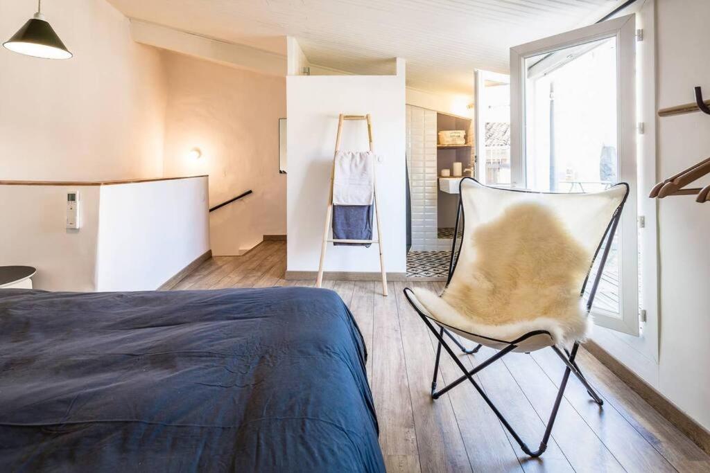 1 dormitorio con 1 cama y 1 silla en una habitación en Hypercentre terrasse clim, en Aix-en-Provence