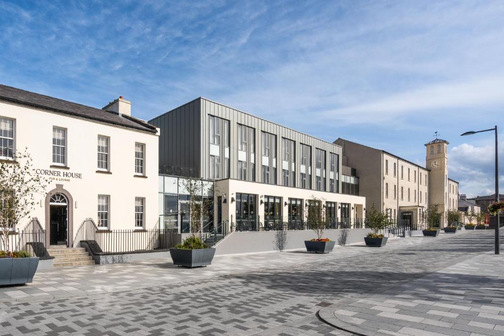 un grand bâtiment avec une cour ornée de plantes en pot dans l'établissement The Ebrington Hotel, à Derry Londonderry