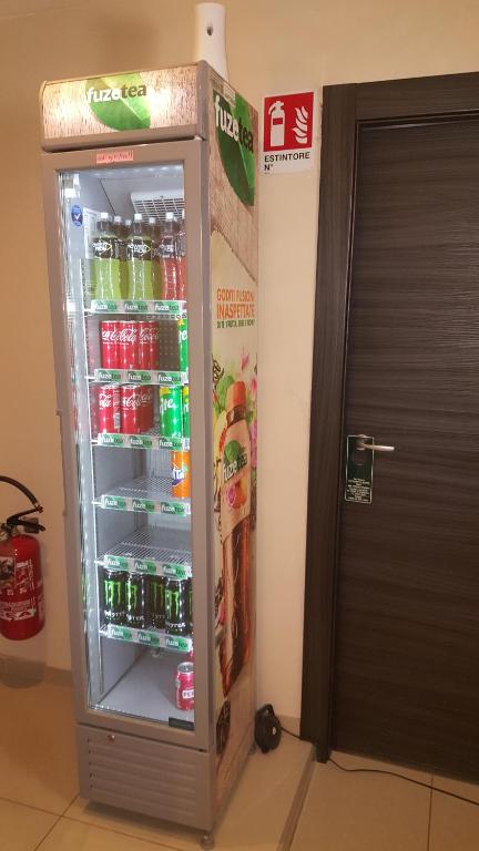 a refrigerator filled with soda and sodas next to a door at Candia Rooms in Rome