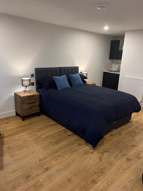 um quarto com uma cama grande e almofadas azuis em Green haven em Winford